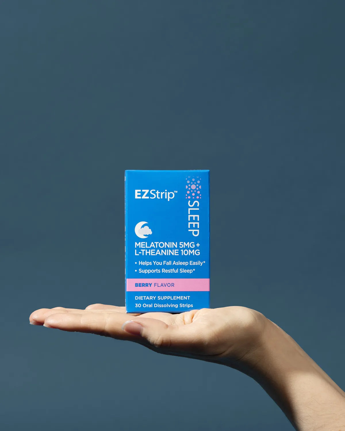 A hand holding a blue EZStrip Sleep box against a dark blue background.