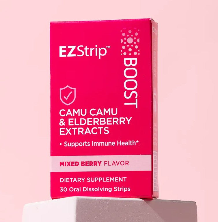 EZStrip Boost dietary supplement box featuring Camu Camu and Elderberry extracts, placed on a white stand against a pastel pink background