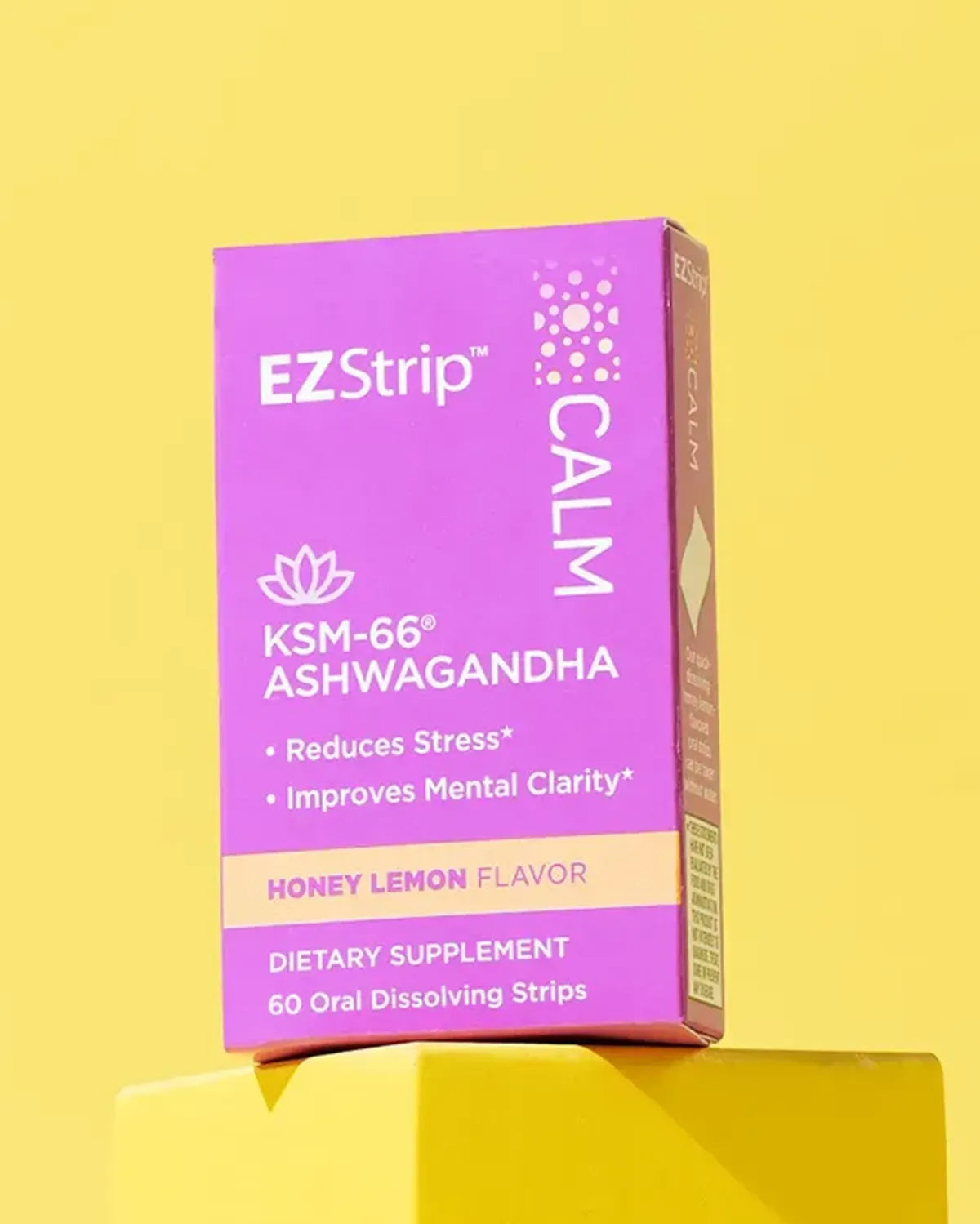 A purple EZStrip Calm supplement box with ashwagandha, placed on a yellow platform with a vibrant background.